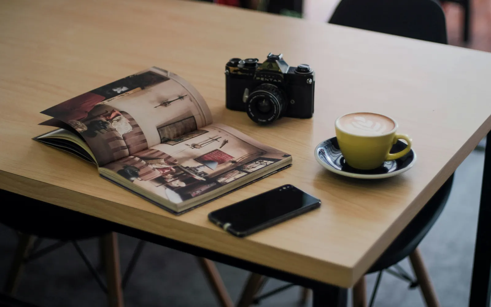 Mesa con café, revista y móvil para leer guías del sector